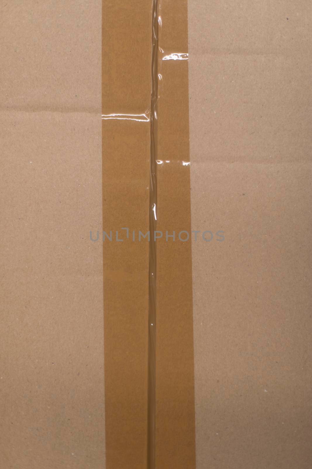 Cardboard box is taped with adhesive tape. Packing of goods. Texture paper and adhesive tape.