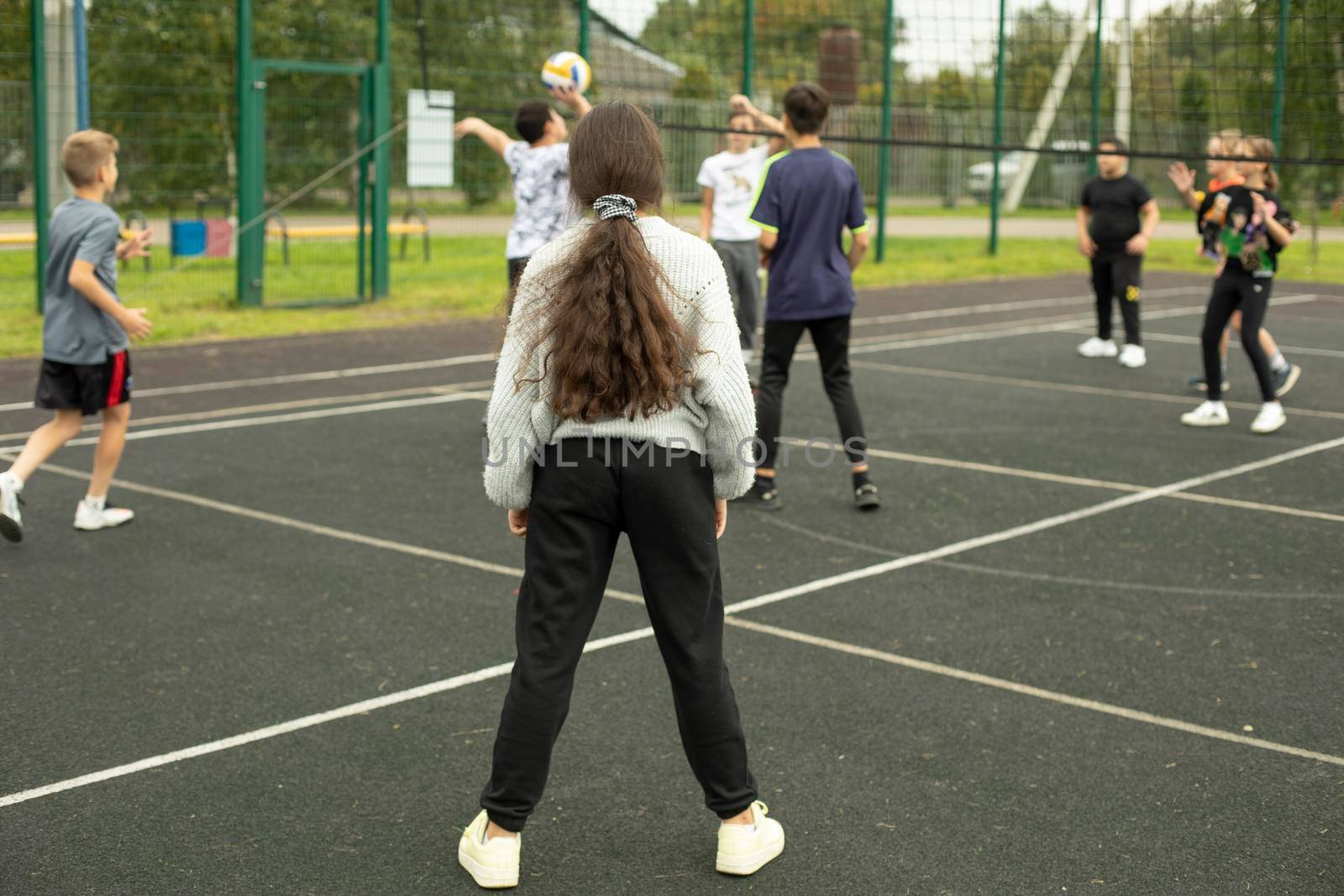 Children play volleyball. Playing ball on court. Sports activity. by OlegKopyov