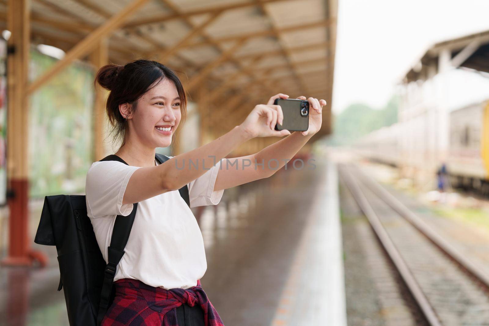 Young traveler woman taking photo trip at train station. Summer and travel lifestyle concept