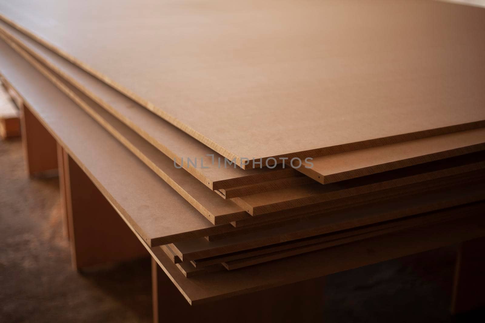 Boards are stacked. Plywood sheet. Joinery. They made furniture production. Building material in garage. Raw wood. Material made of pressed sawdust.