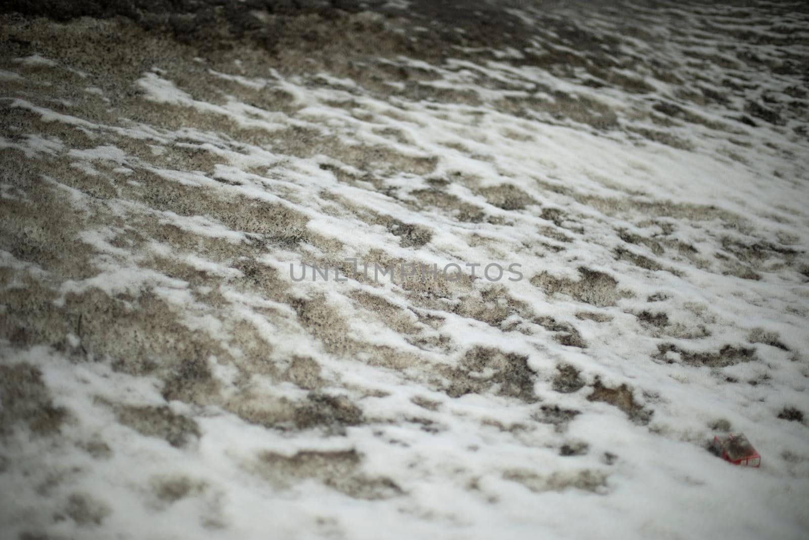 Dirty snow on side of road. Snow melts on asphalt. Situation on road after precipitation. by OlegKopyov