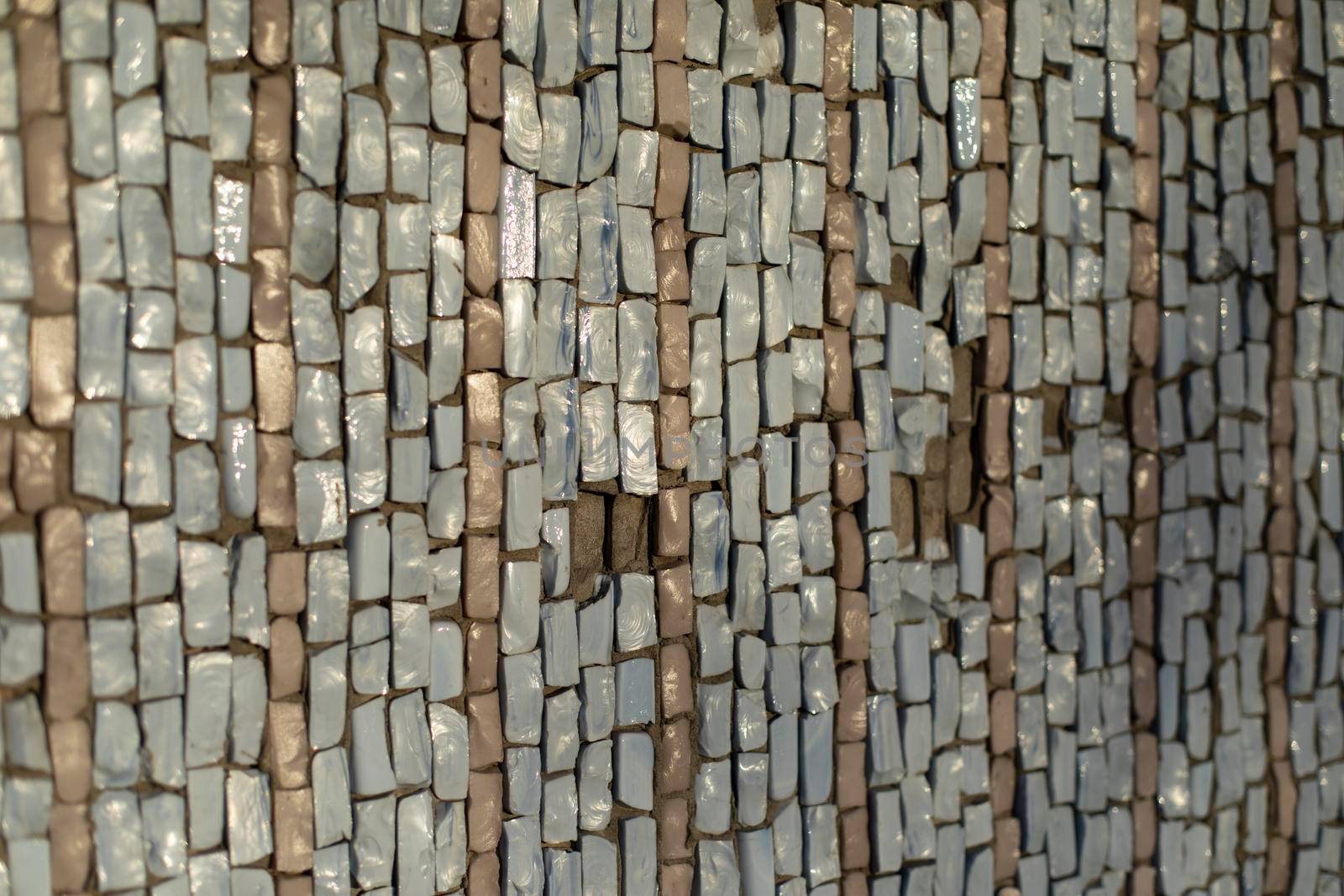 Mosaic texture. Wall is made of pieces of glass. Colored stone. Architecture details.