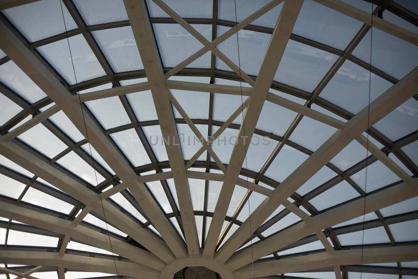 Dome roof made of glass and fittings. Steel beams form circle. Glazed roof of shopping center.