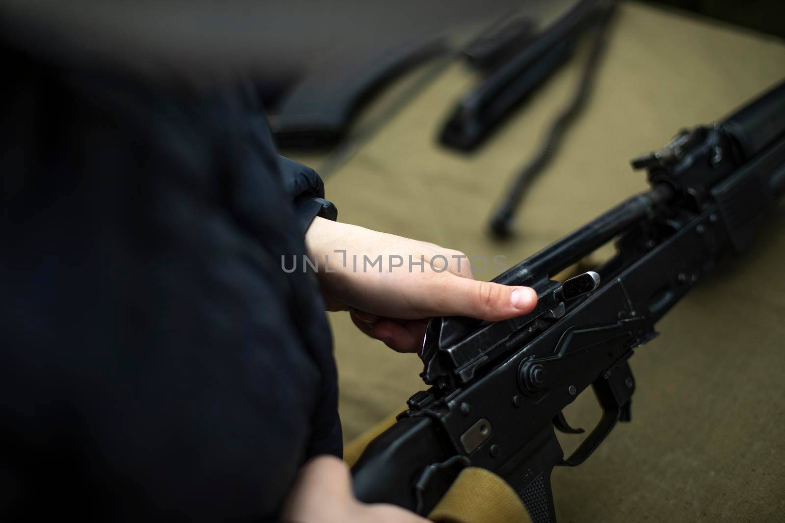 Children learn to shoot in Russia. Assembly of automatic weapons. Lesson in military training. Details of war training. Hands hold barrel of machine gun.