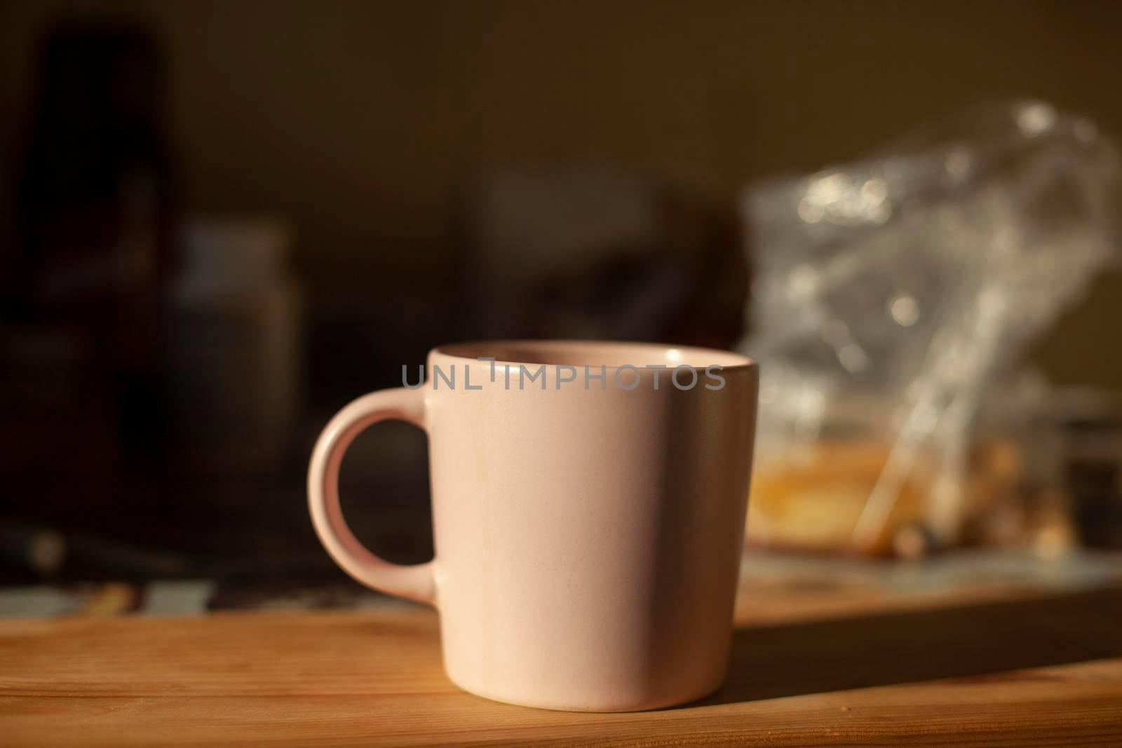 Cup on table. Kitchen details. Light on dishes. Morning drink. Tea for breakfast.