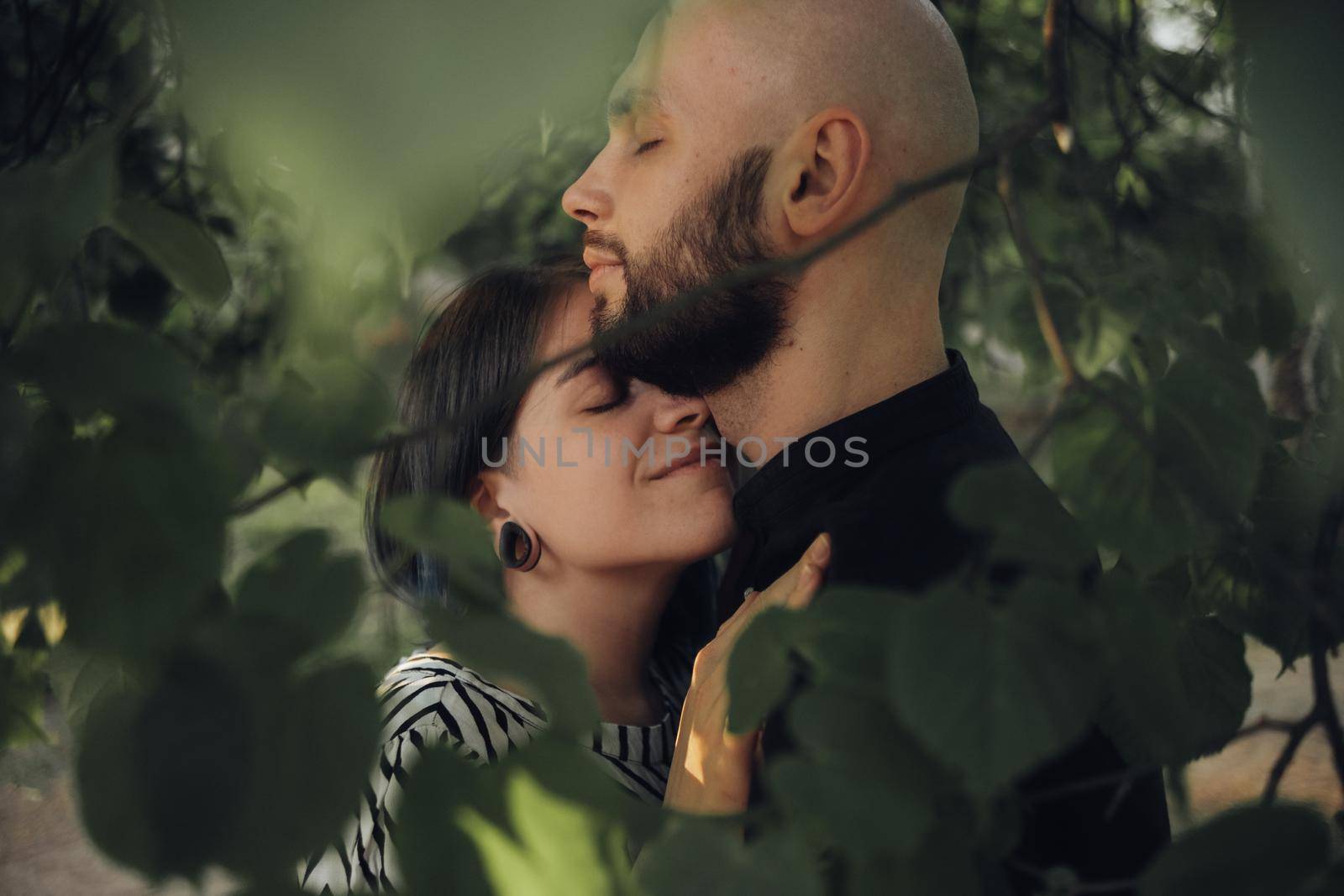 the couple in love hid from everyone in the foliage of the tree. gently hugged by Symonenko