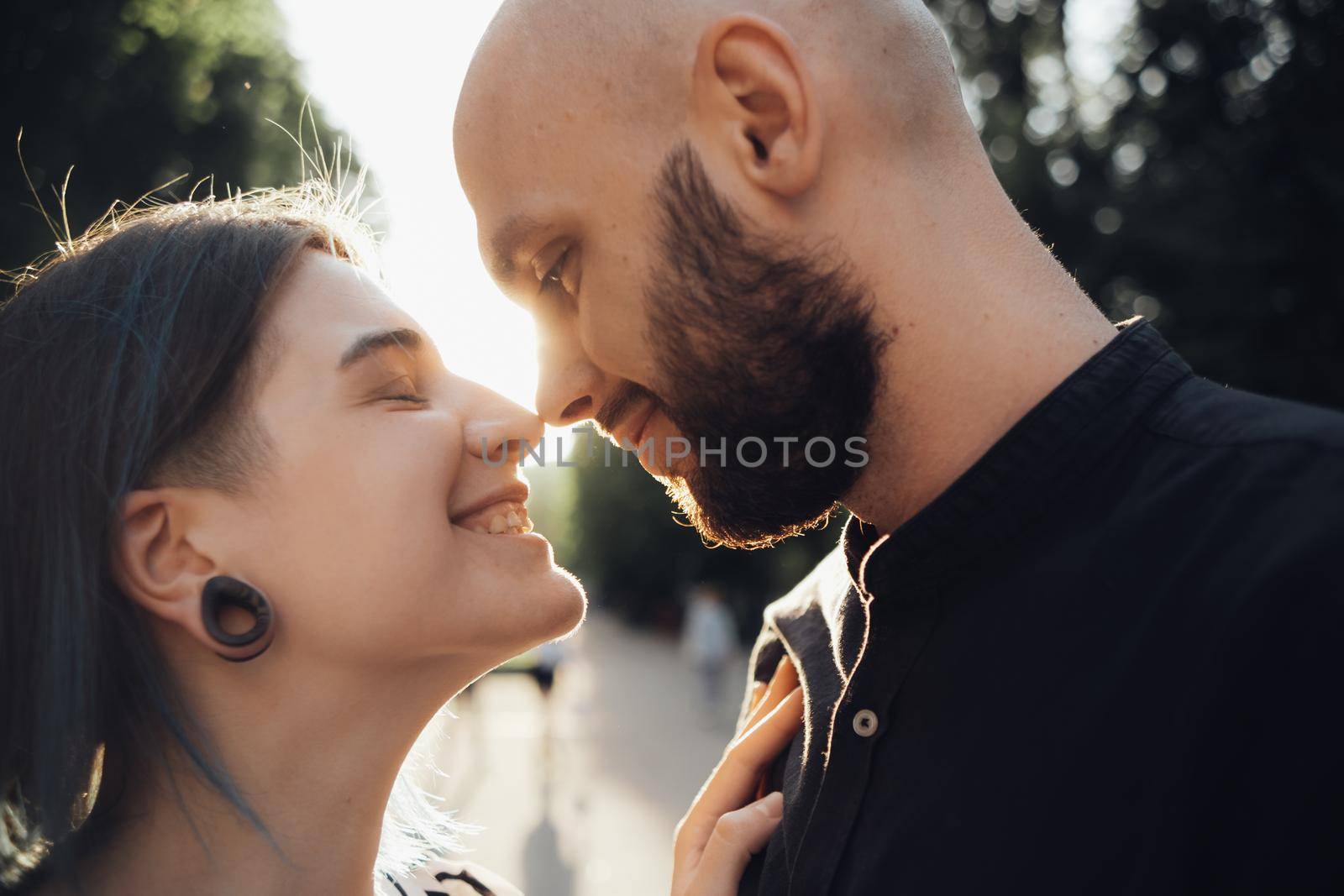 a loving couple hugs and looks into each other's eyes against the background of the summer sun. closeup by Symonenko