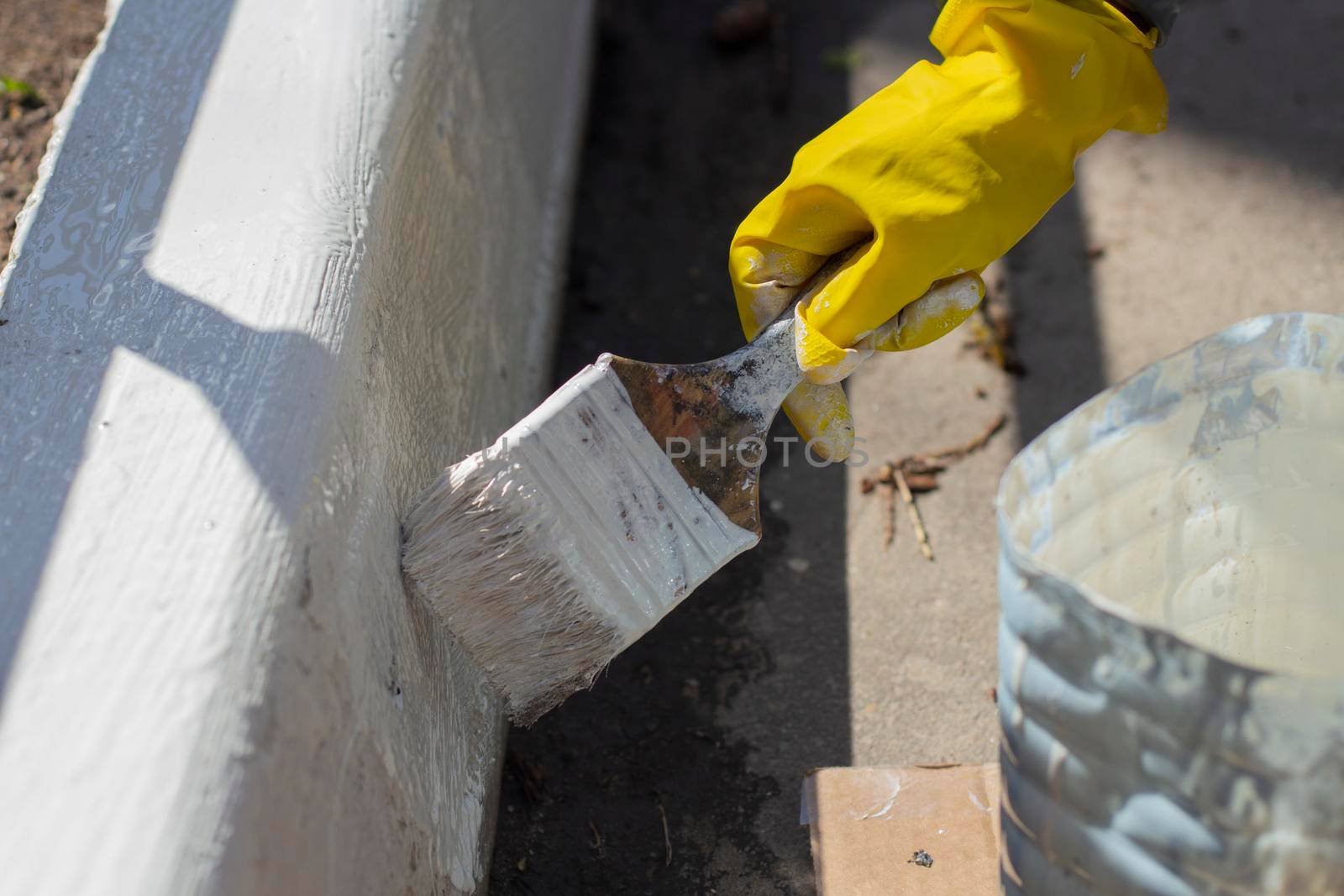 Painting borders with white paint. Applying oil paint to asphalt. by OlegKopyov