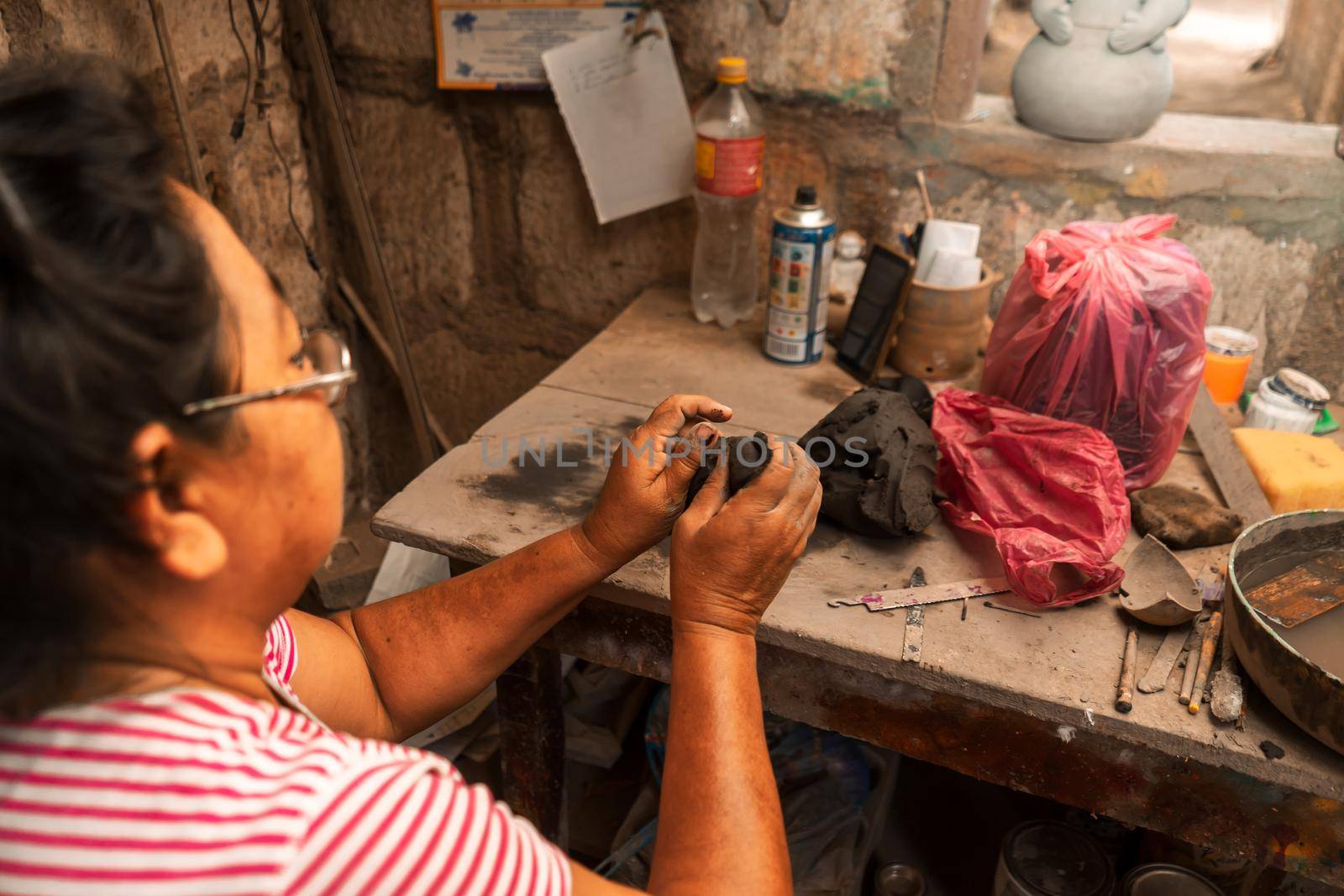 Woman working in her clay crafts workshop in La Paz Central Nicaragua molding a piece with her hands