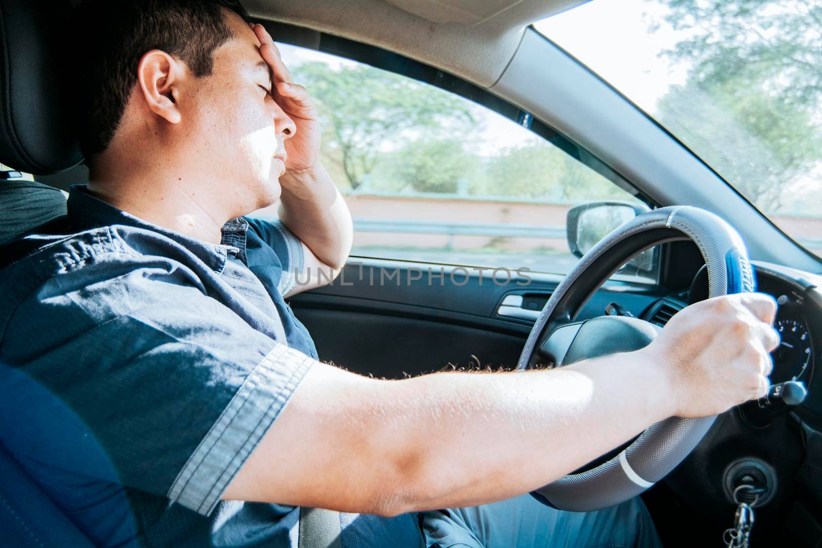 fatigued driver stuck in traffic, concept of a fatigued man in his car, stressed. A driver with a headache in traffic, A person with a headache in traffic