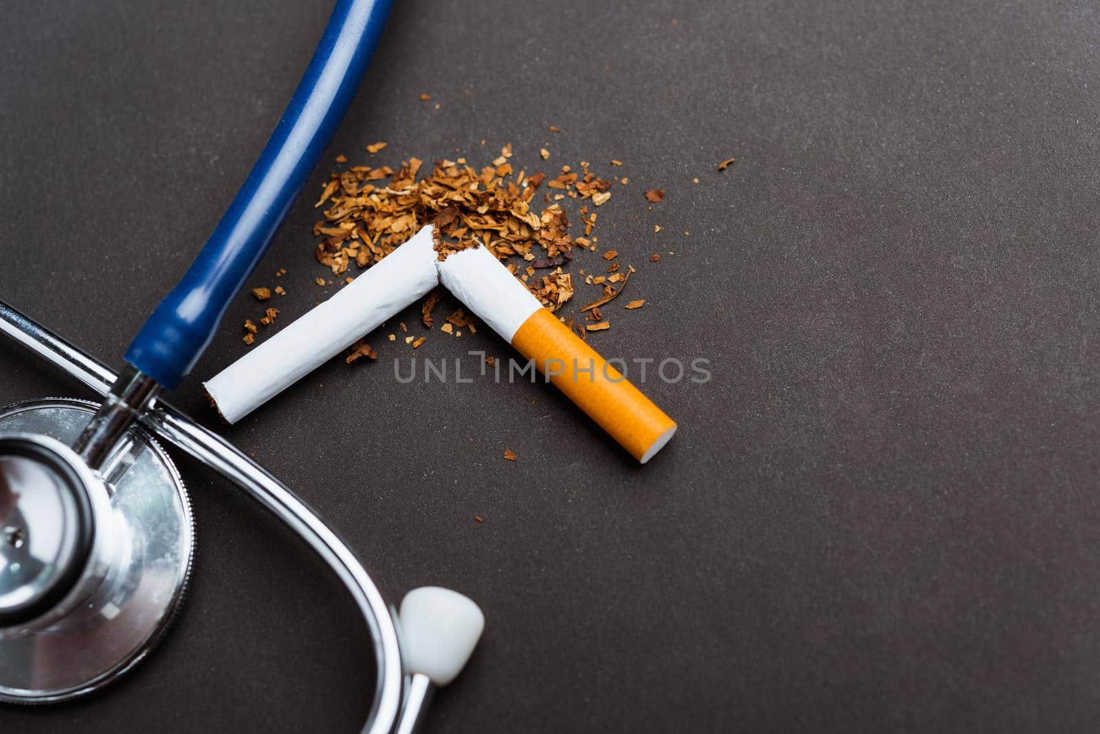 31 May of World No Tobacco Day, no smoking, close up of broken pile cigarette or tobacco and doctor stethoscope on black background with copy space, and Warning lung health concept