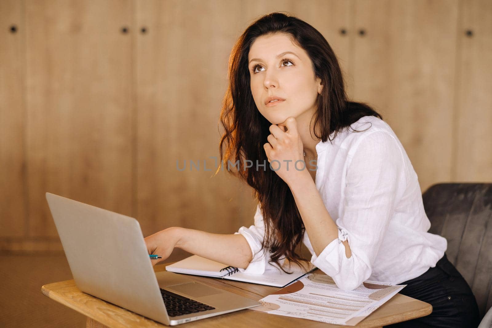 Beautiful woman sitting in the office working on a laptop.