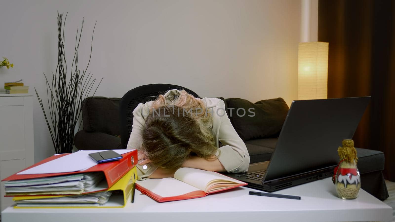 Tired stressed overworked Caucasian business woman falling asleep at desk, sitting at table with laptop. Depressed unmotivated freelancer lying on table, feeling boredom working from home. Insomnia.