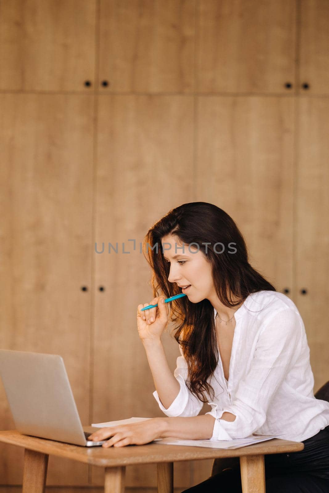 Beautiful woman sitting in the office working on a laptop.