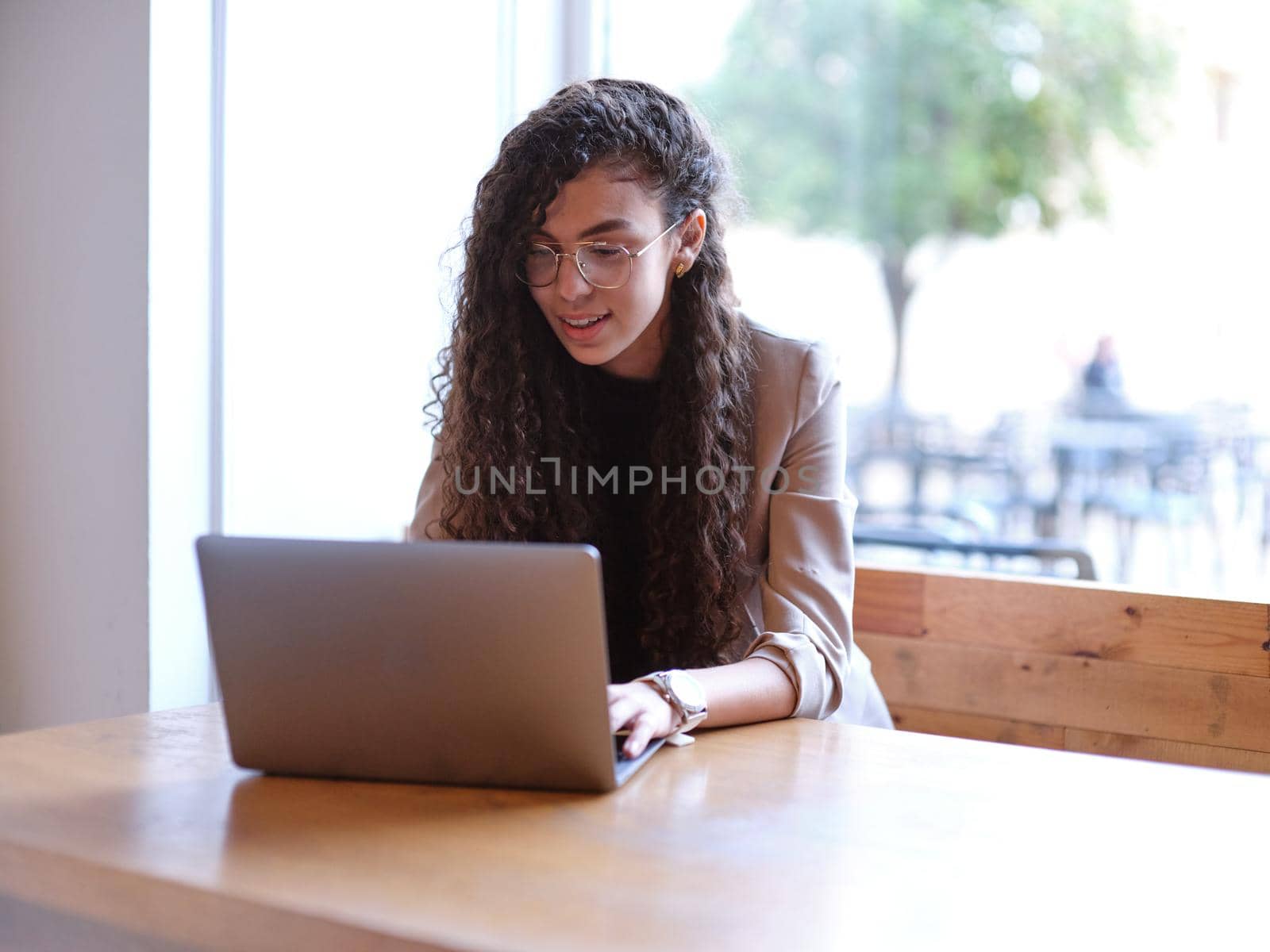 woman working in a coffee shop from her laptop computer, horizontal close up