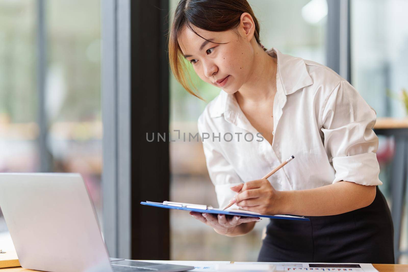 Portrait of Business woman hand holding pen and analyze financial. Account and Finance concept