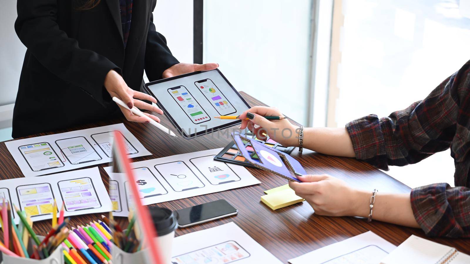 Group of website developer sketching wireframe layout design application for mobile phone.