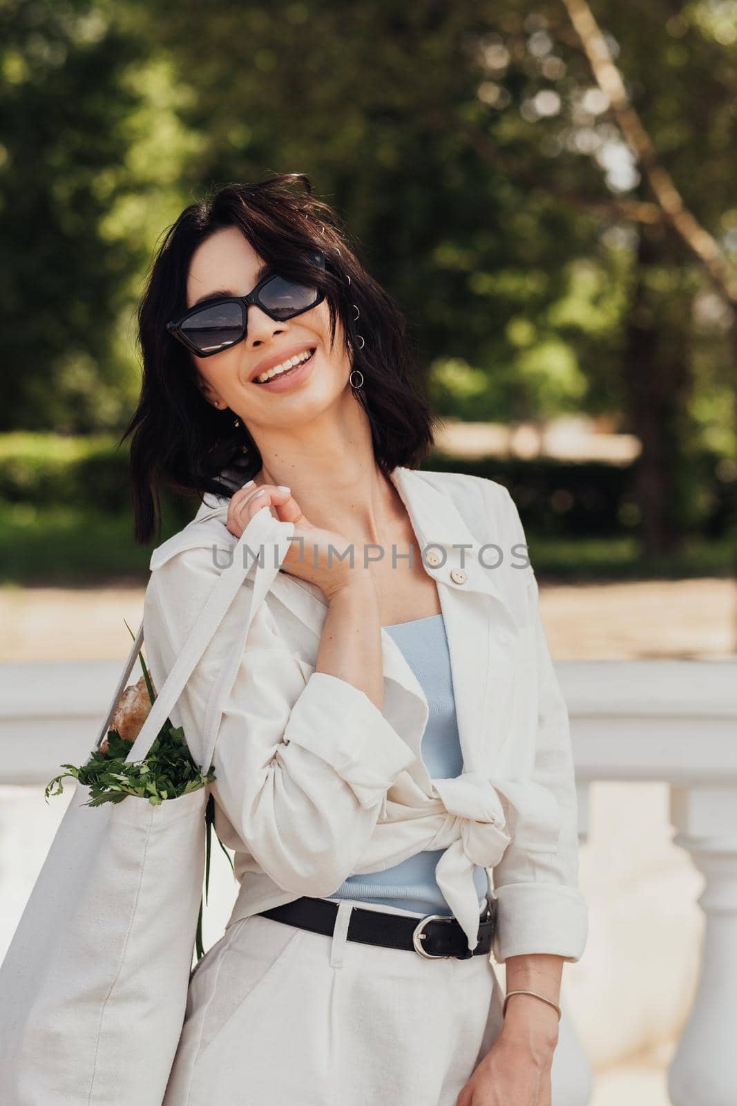 Vertical Portrait of Cheerful Brunette Woman Holding Shopping Eco Bag Outdoors at Sunny Summer Day