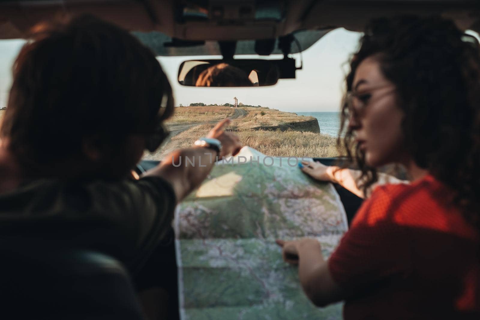 Back View of Man and Woman Sitting in Car and Checking Map, Young Couple Enjoying Road Trip