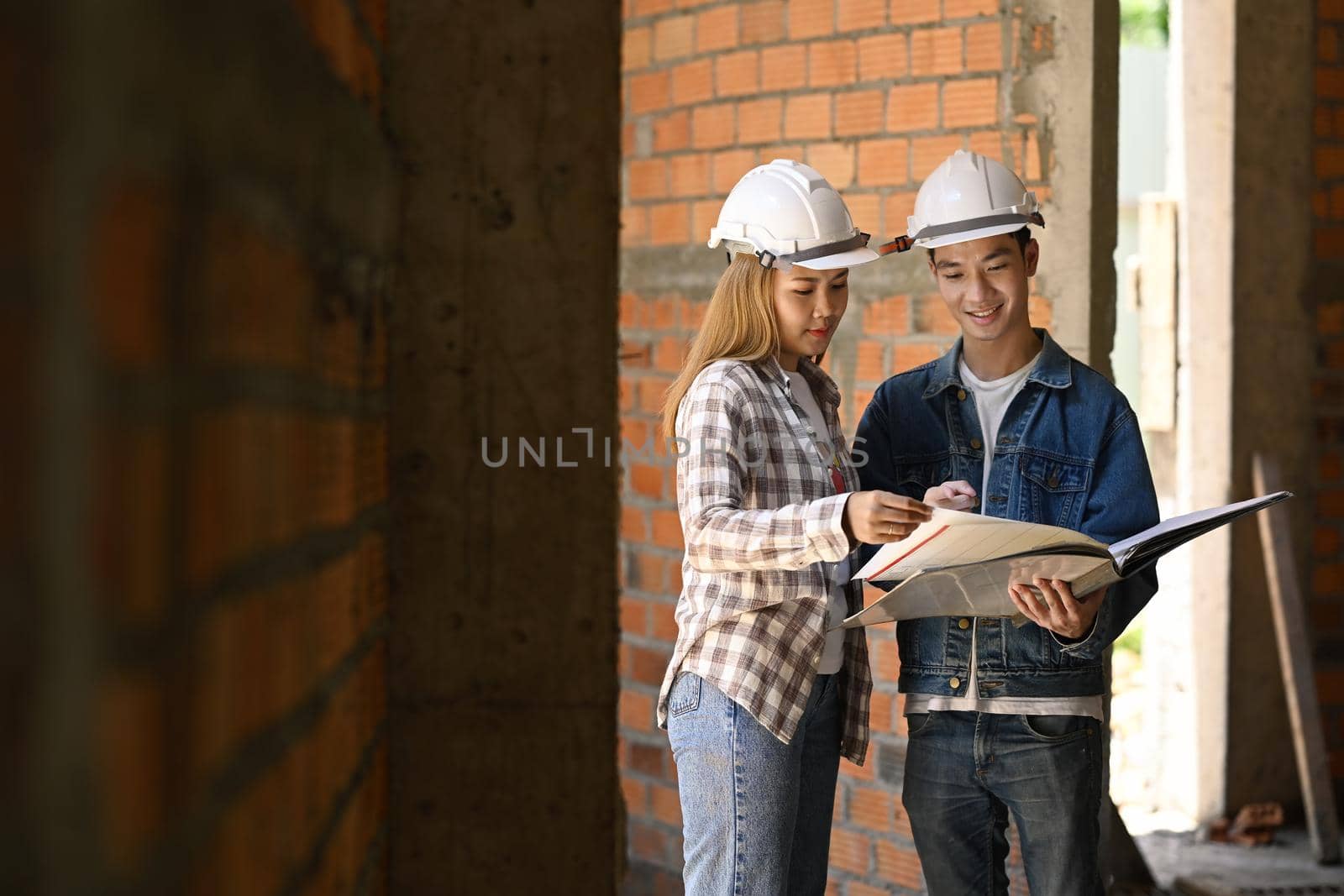 Specialists inspecting commercial building Construction site with civil engineer.