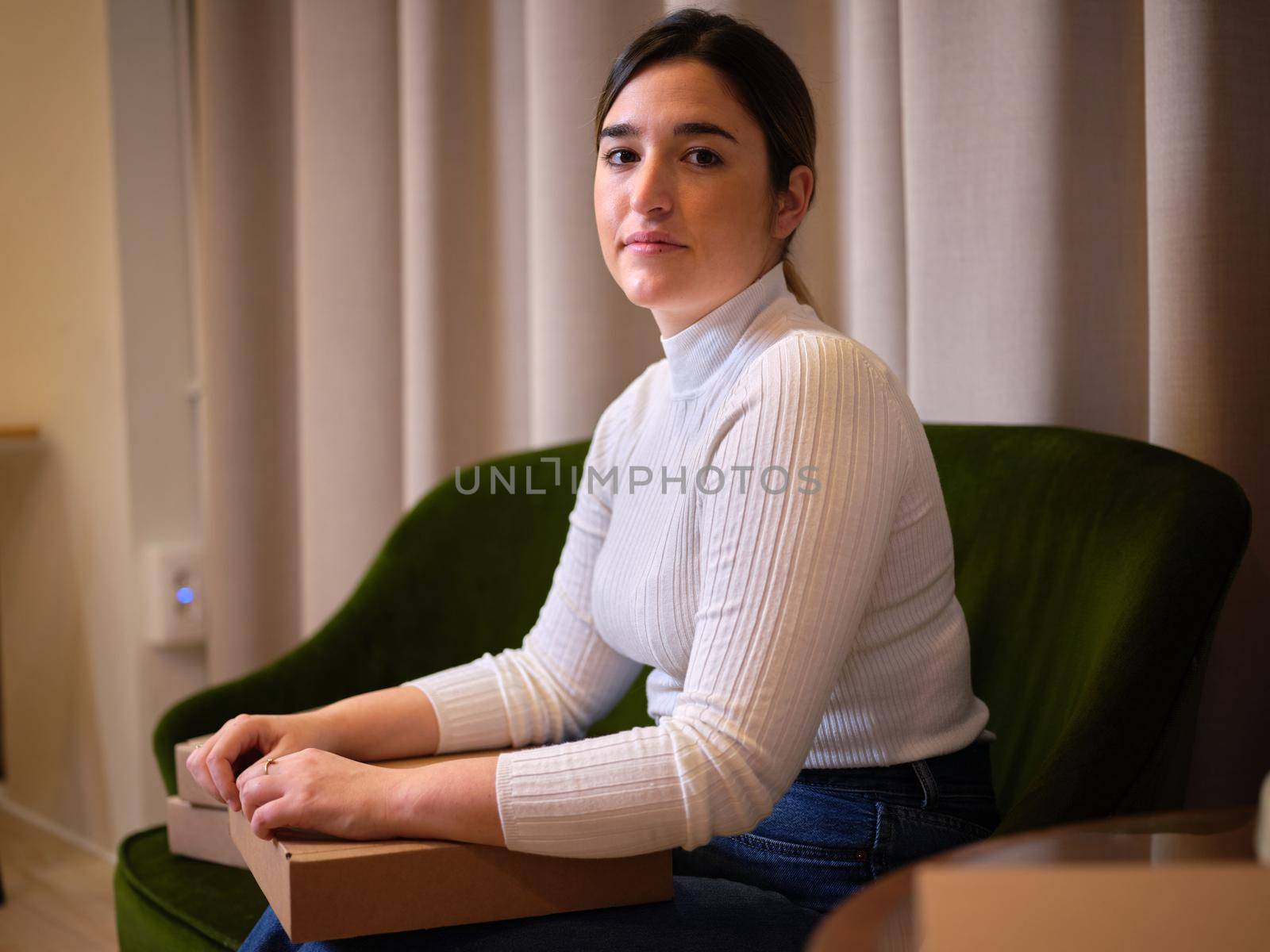 adult woman sitting with the box of her new product in a coworking space by WesternExoticStockers