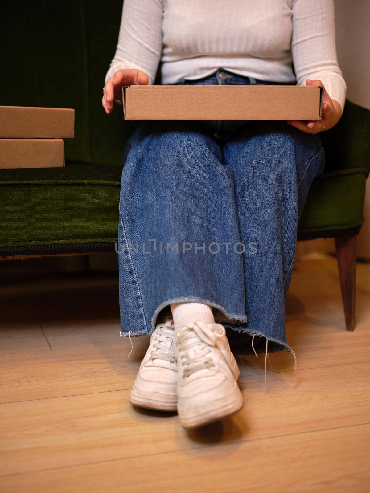 view from below of a girl sitting with a box on her legs, vertical close up