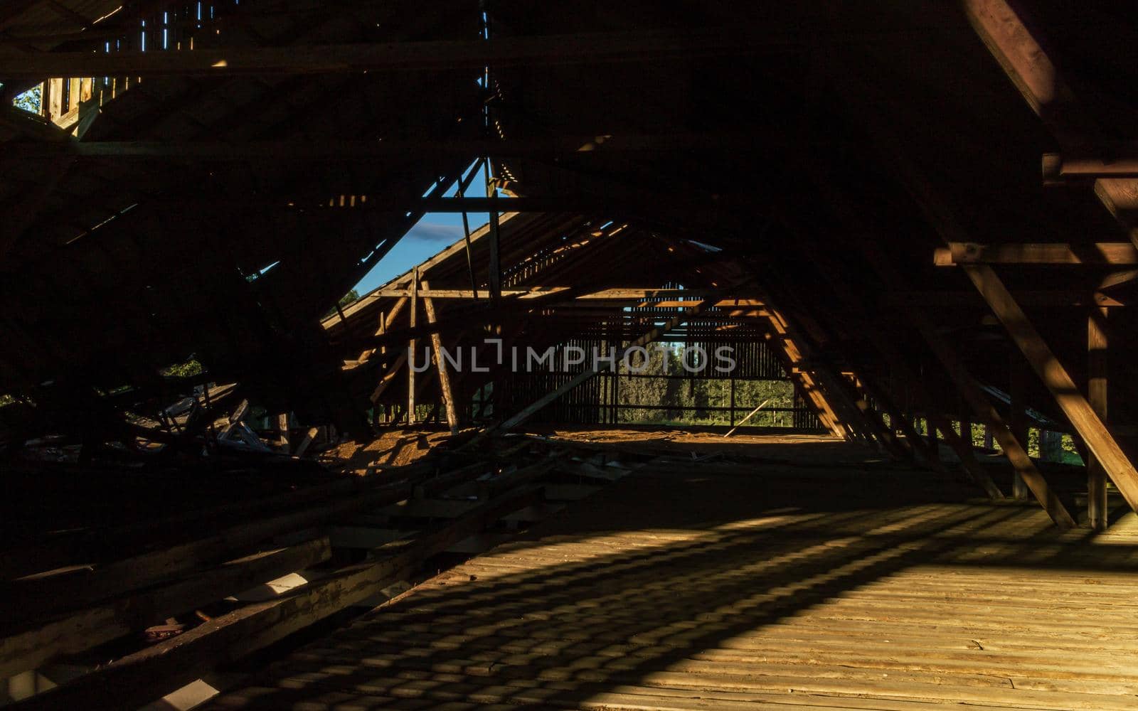 Old farm building underconstruction roof top room, sunshine on the wood floor and broken roof
