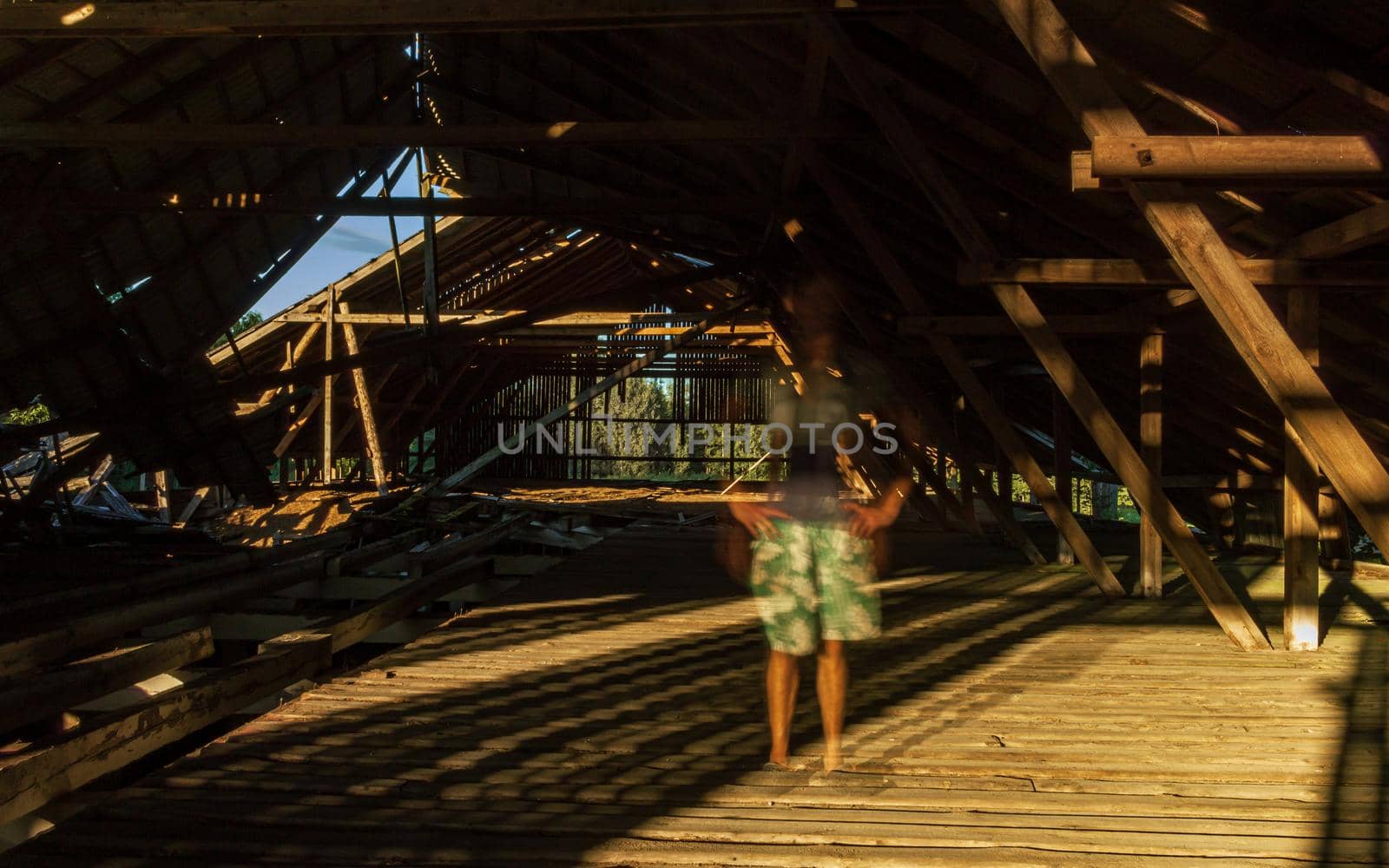 Old farm building underconstruction roof top room ghost standing, sunshine on the wood floor and broken roof