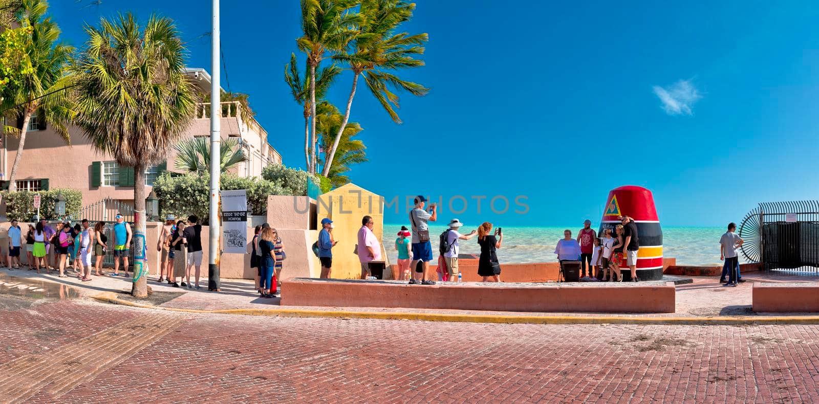 Key West, Florida, USA, March 30 2022: The Key West marker the southernmost point on the continental USA and distance to Cuba, Florida, USA. Famous tourist attraction in Key West. Tourists waiting in row to tak photo.