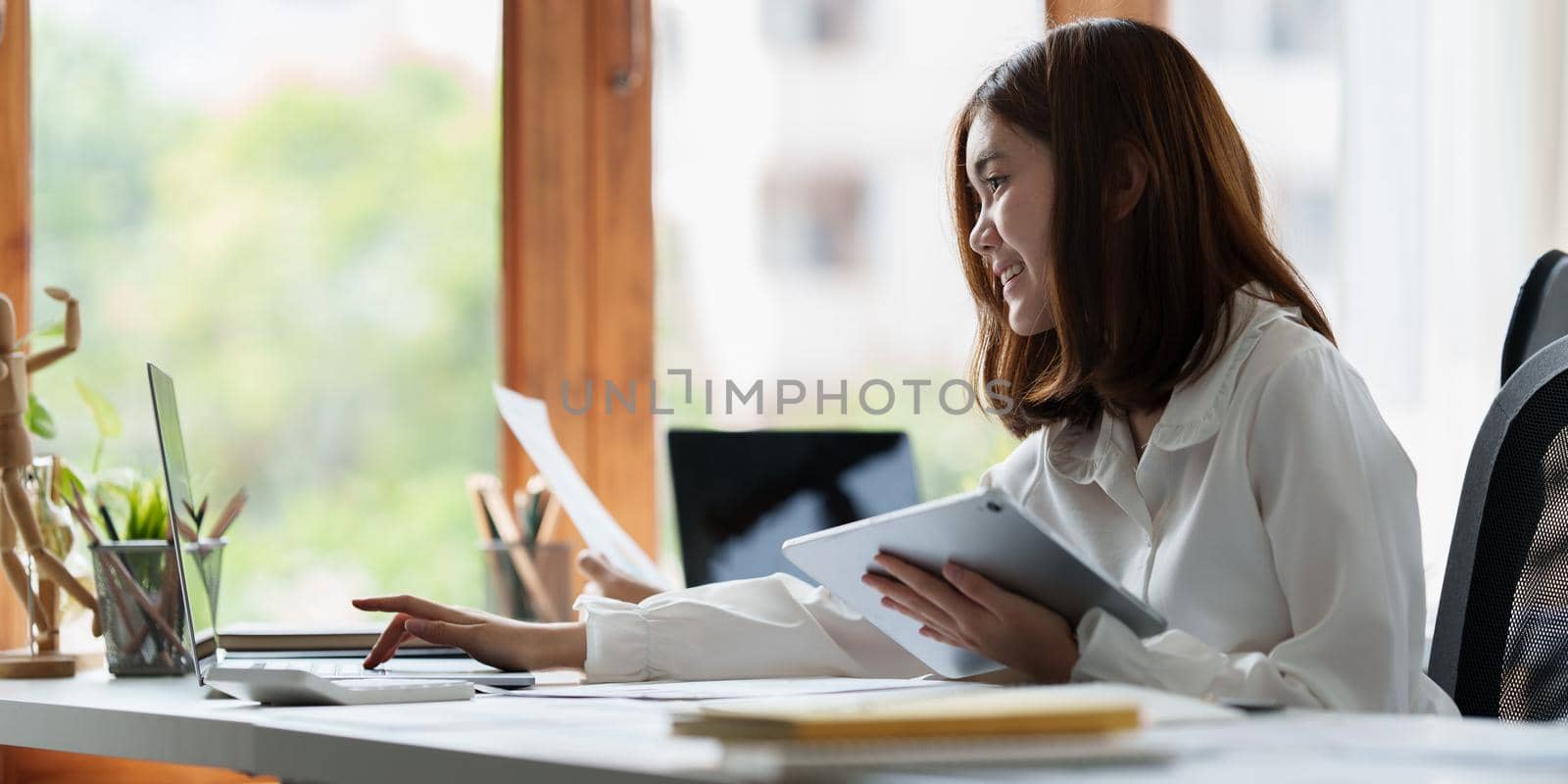 Close up Business woman hand using calculator to calculate the company's financial results and budget. Account Audit Concept