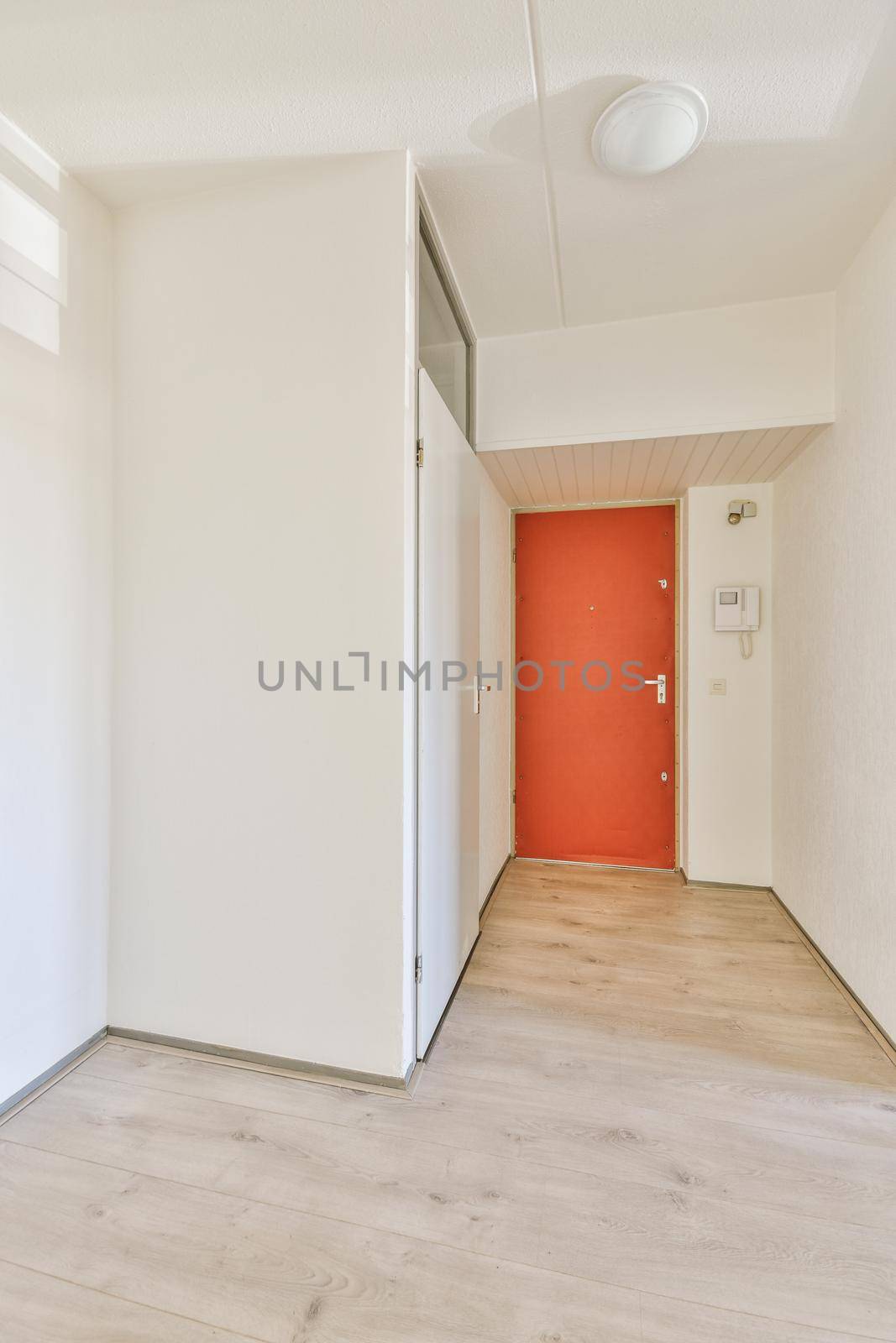 Interior of modern flat in minimal style with narrow empty corridor illuminated by lamps