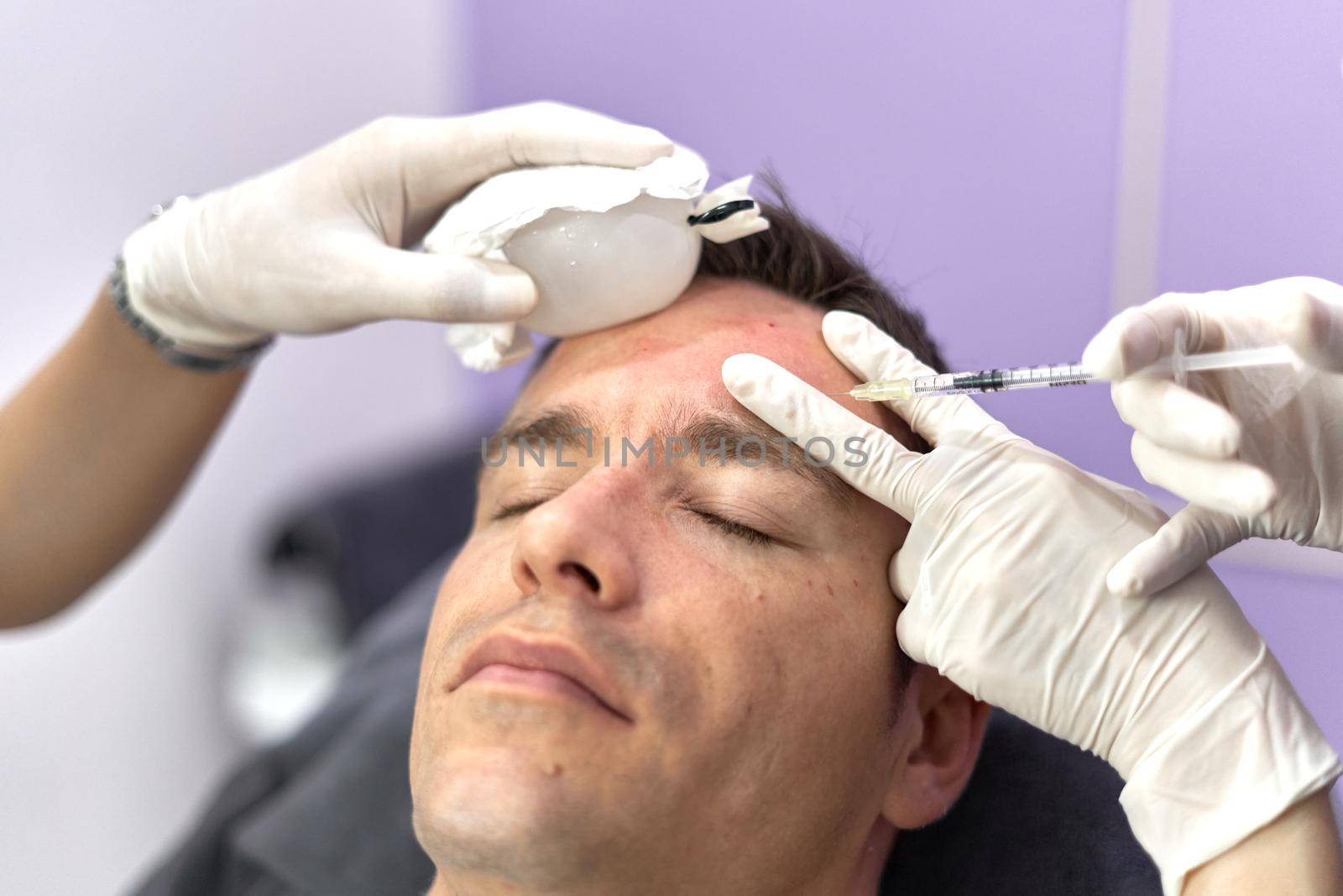 Nurse applying ice to the face of a patient while receiving a botox vaccine by WesternExoticStockers