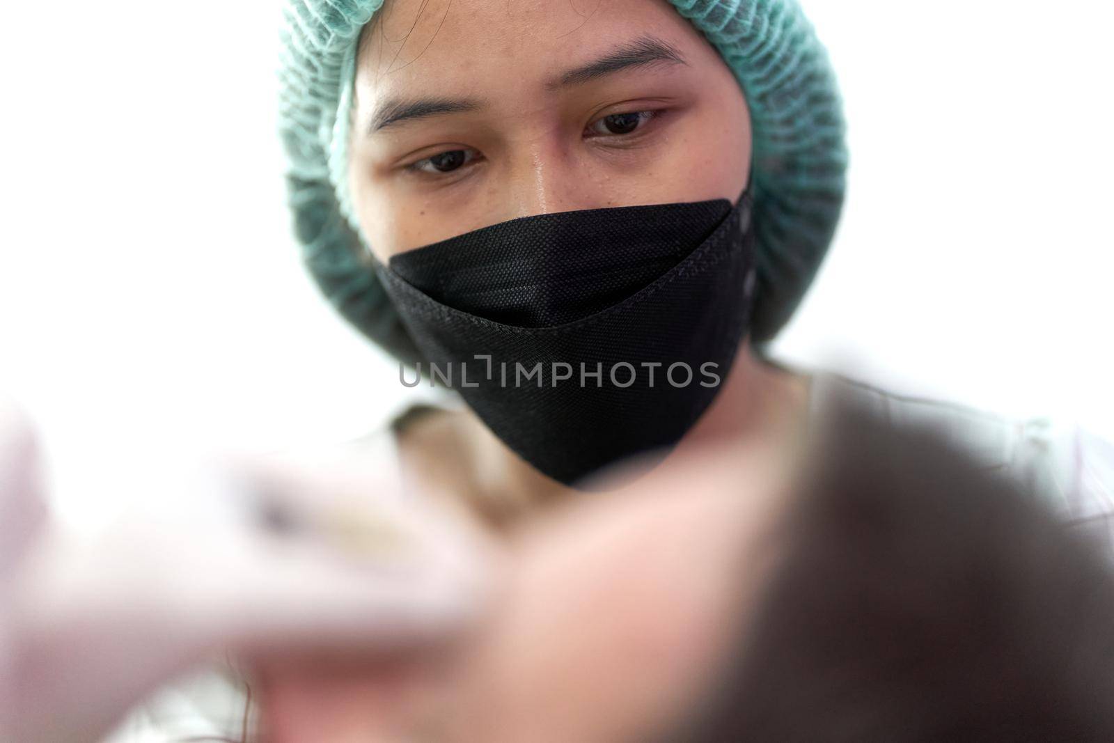Portrait of a nurse looking to a patient that receives a beauty treatment by WesternExoticStockers