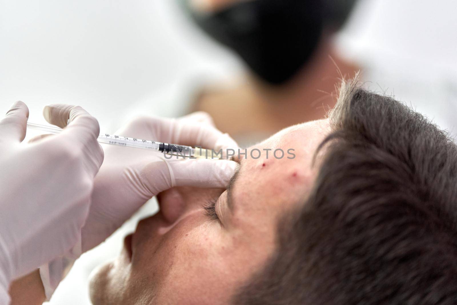 Focus on a collagen injection entering the skin of the forehead of a patient in a clinic