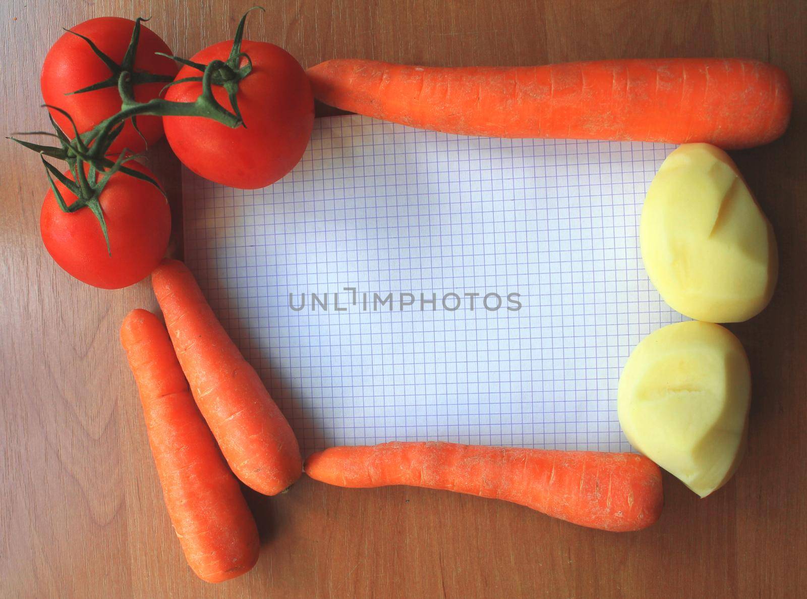 tomatoes and carrot on a wooden background with sheet of paper and potatoes by JackyBrown