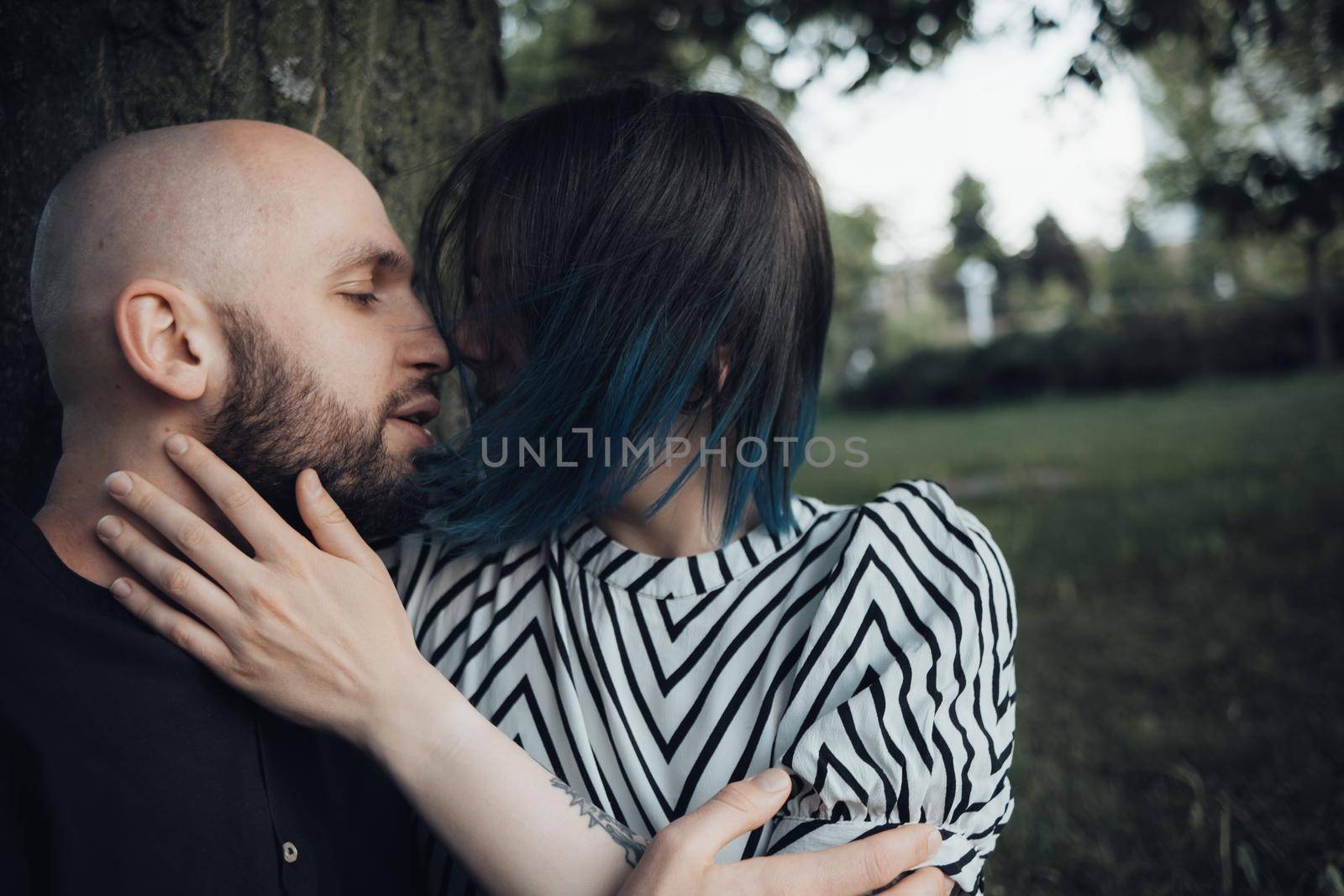 lovers sit in the park under a tree, talk and hug by Symonenko