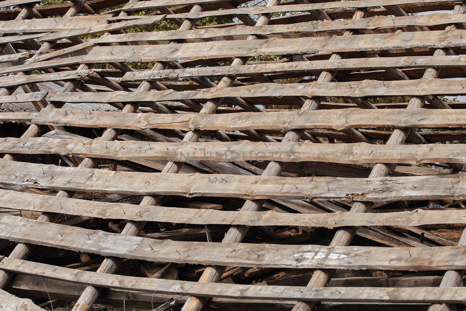 Old ruined, holey roof, removed slate roof tiles on a pitched roof, The internal board structure of the ancient roof