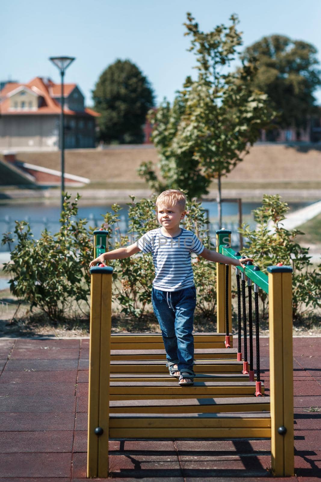 A full-length portrait of a little boy in a striped sailor shirt in the port city of Klaipeda by Lincikas