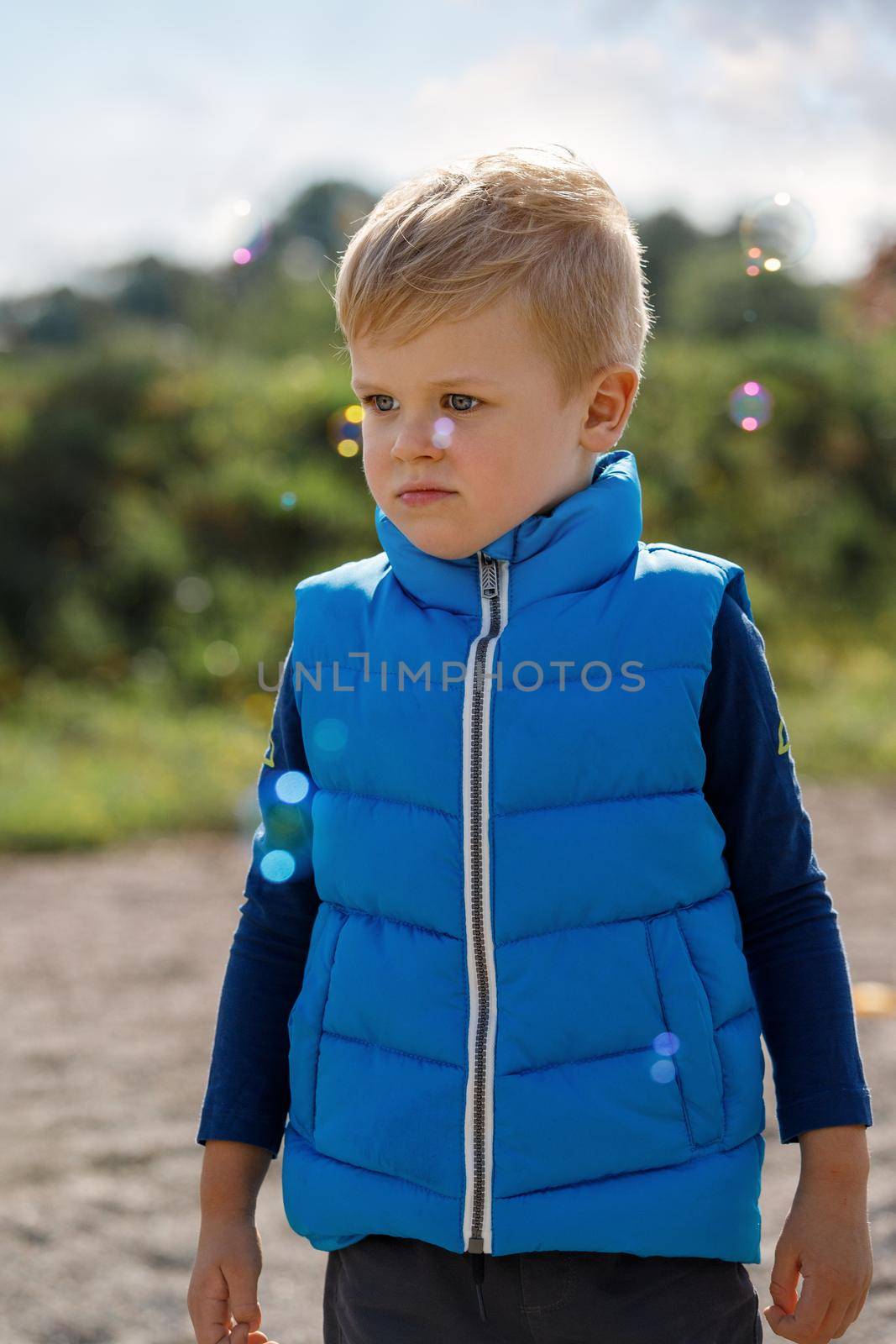 Little boy playing on the fresh air. Unhappy little boy and bubbles. by Lincikas