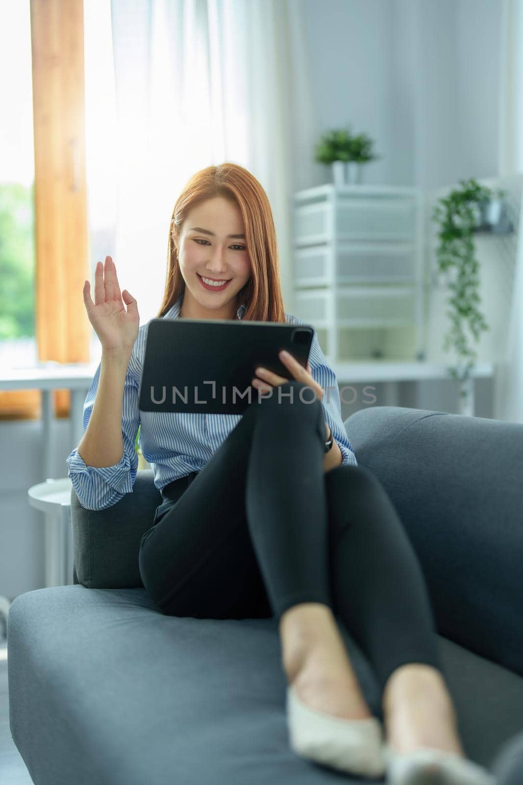 Conversation, online teaching, explaining, meeting, business owner, portrait of an Asian woman using a tablet for video conference with colleagues. work from home in the era of corona virus by Manastrong
