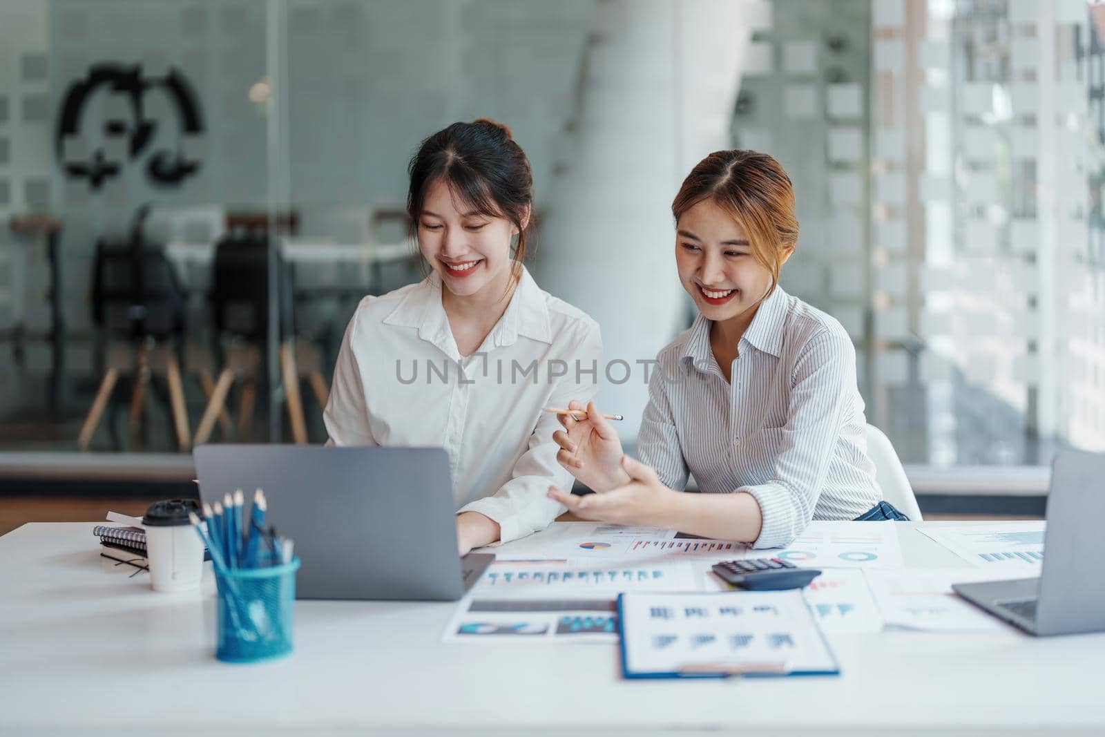 financial, Planning, Marketing and Accounting, portrait of Asian woman Economist using computer and investment documents with partners on profit taking to compete with other companies by Manastrong