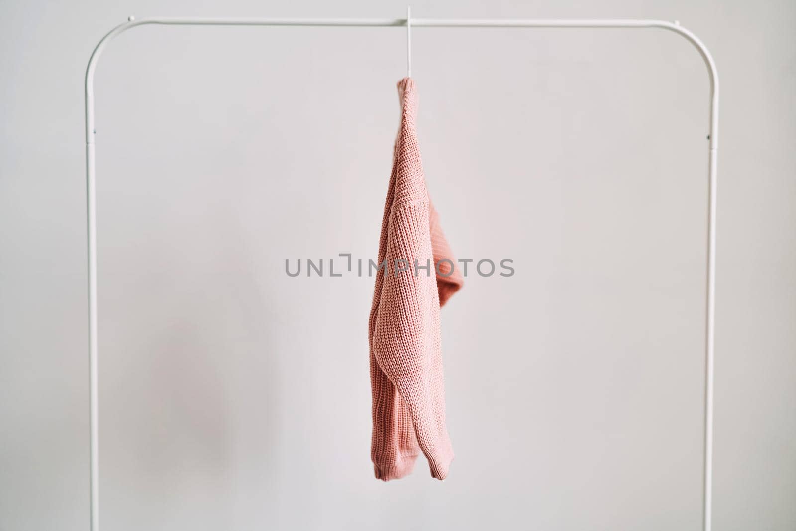 A woolen sweater hanging on a hanger on a white background. Warm clothes sale. Concept - everything is sold out in a clothing store.