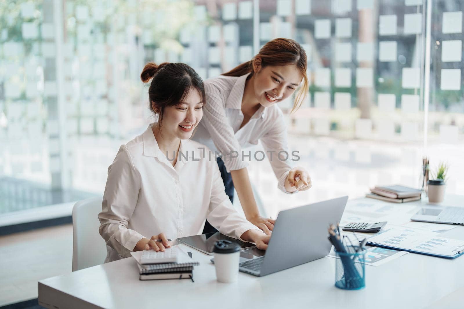 financial, Planning, Marketing and Accounting, portrait of Asian woman Economist using computer and investment documents with partners on profit taking to compete with other companies by Manastrong