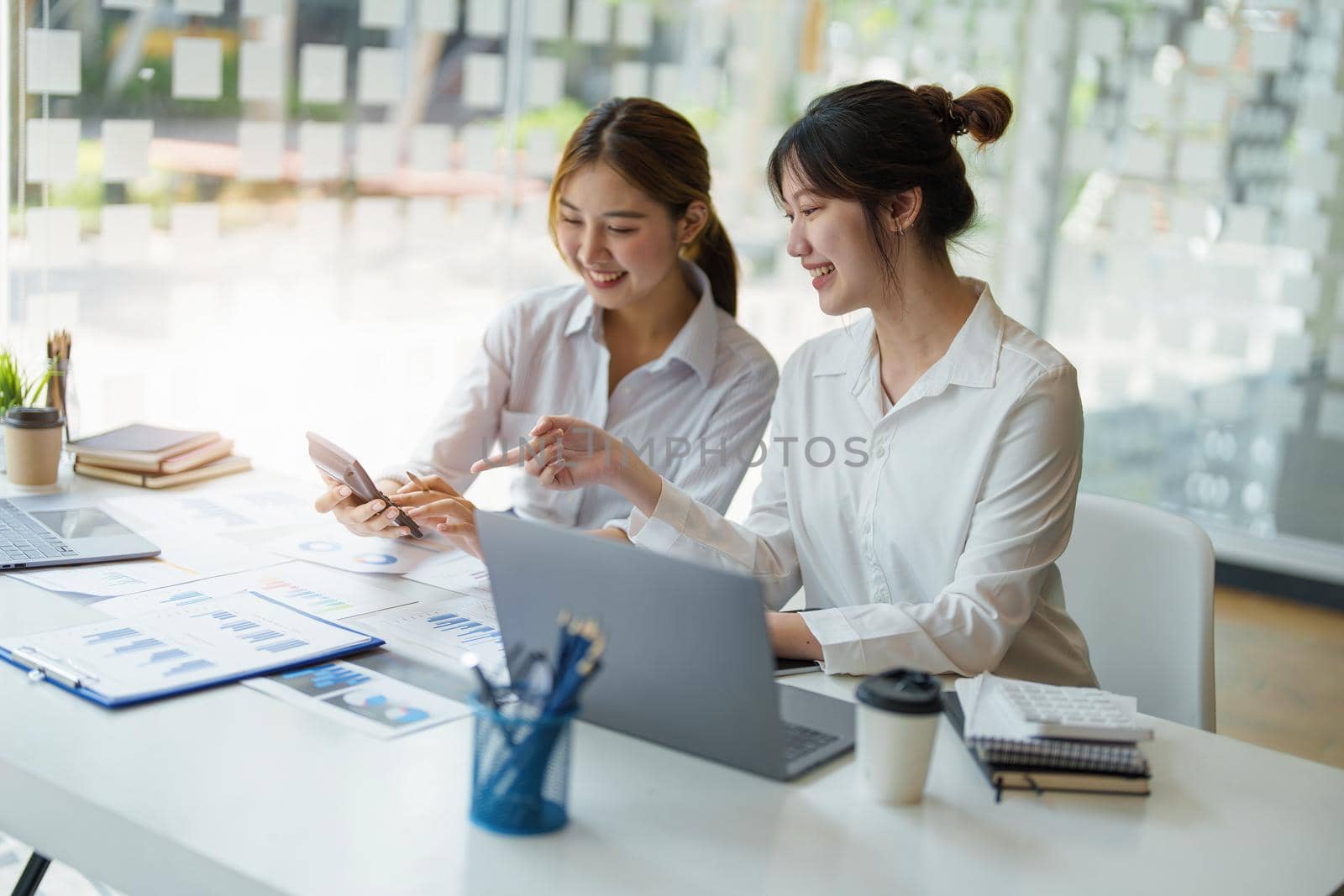 financial, Planning, Marketing and Accounting, portrait of Asian woman Economist using calculator to calculate investment documents with partners on profit taking to compete with other companies by Manastrong