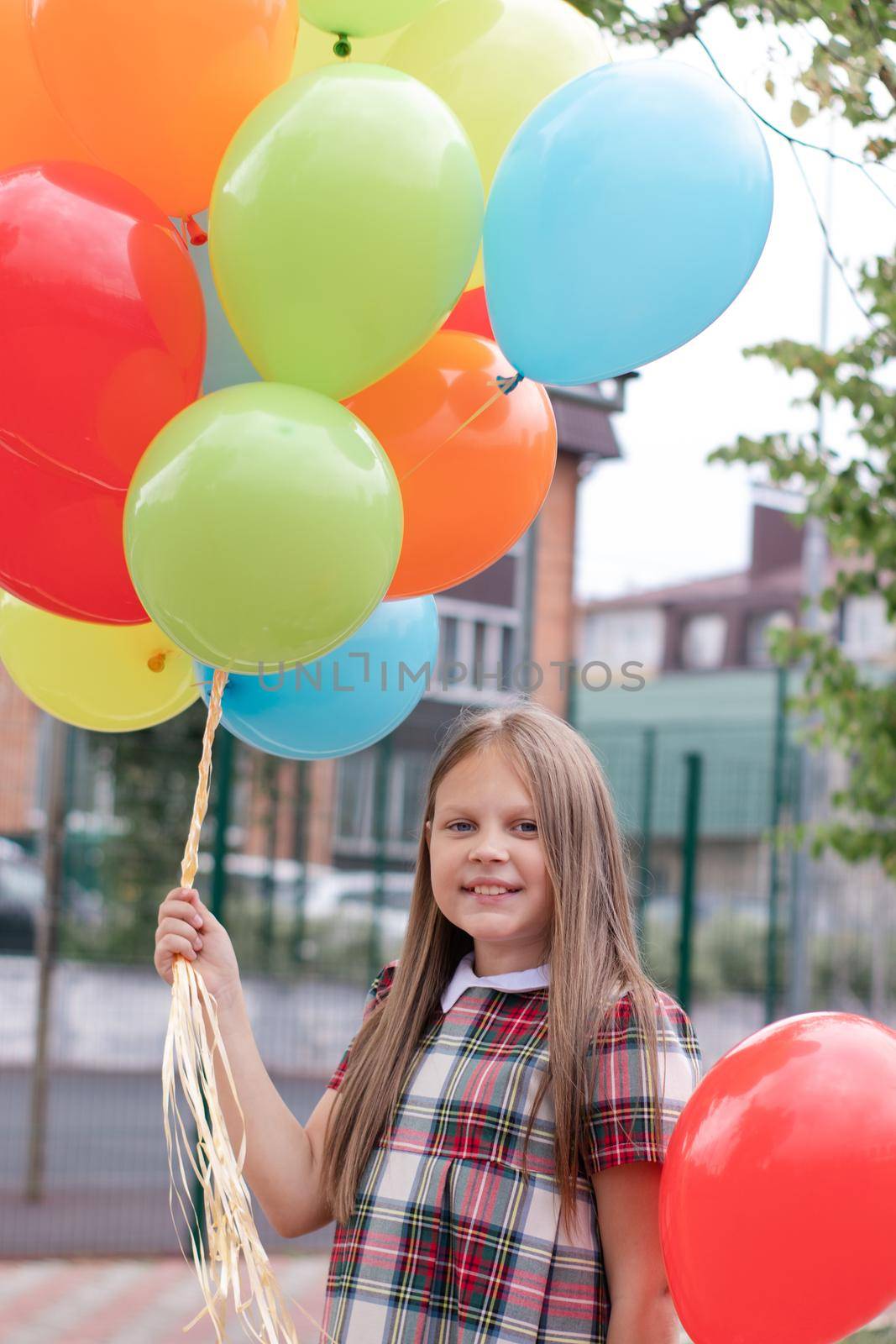 Teenage girl with colorful helium air balloons having fun outdoors. Tween Party. enjoying summer.