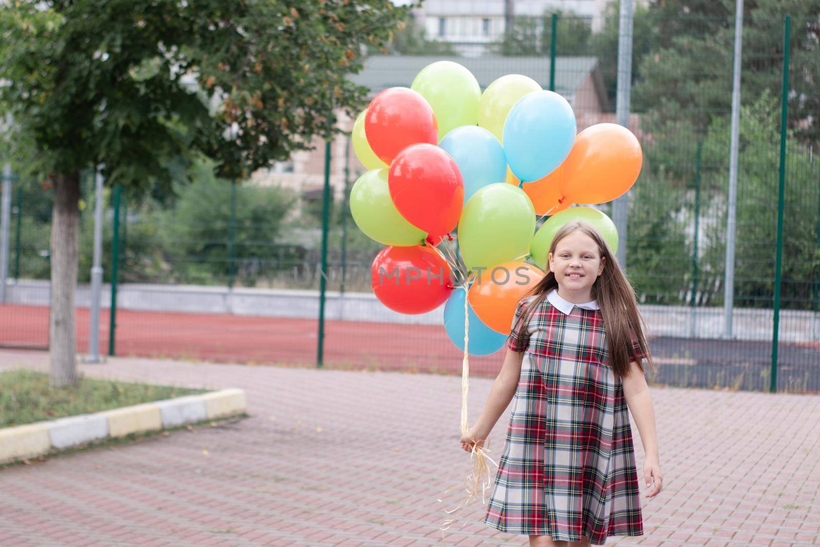 Teenage girl with colorful helium air balloons having fun outdoors. Tween Party. enjoying summer.