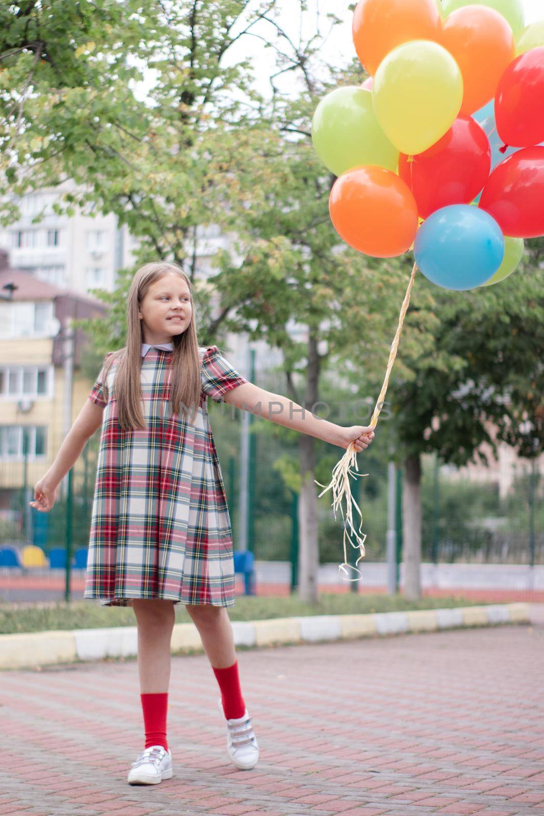 Teenage girl with colorful helium air balloons having fun outdoors. Tween Party. enjoying summer.