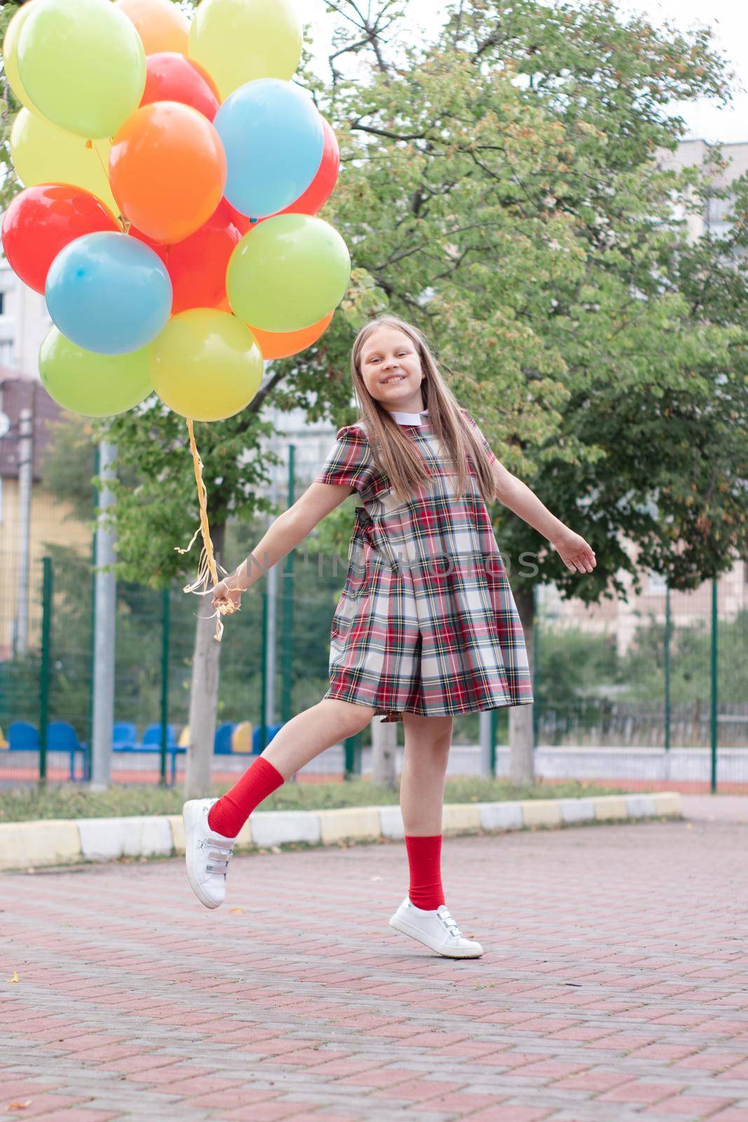 Teenage girl with colorful helium air balloons having fun outdoors. Tween Party. enjoying summer.