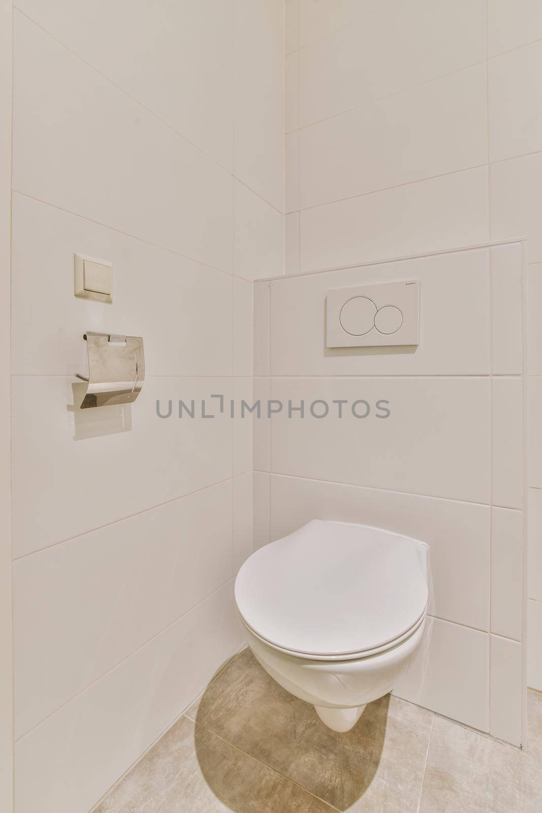 Modern toilet installed on beige wall under button and illuminated shelf in light restroom at home