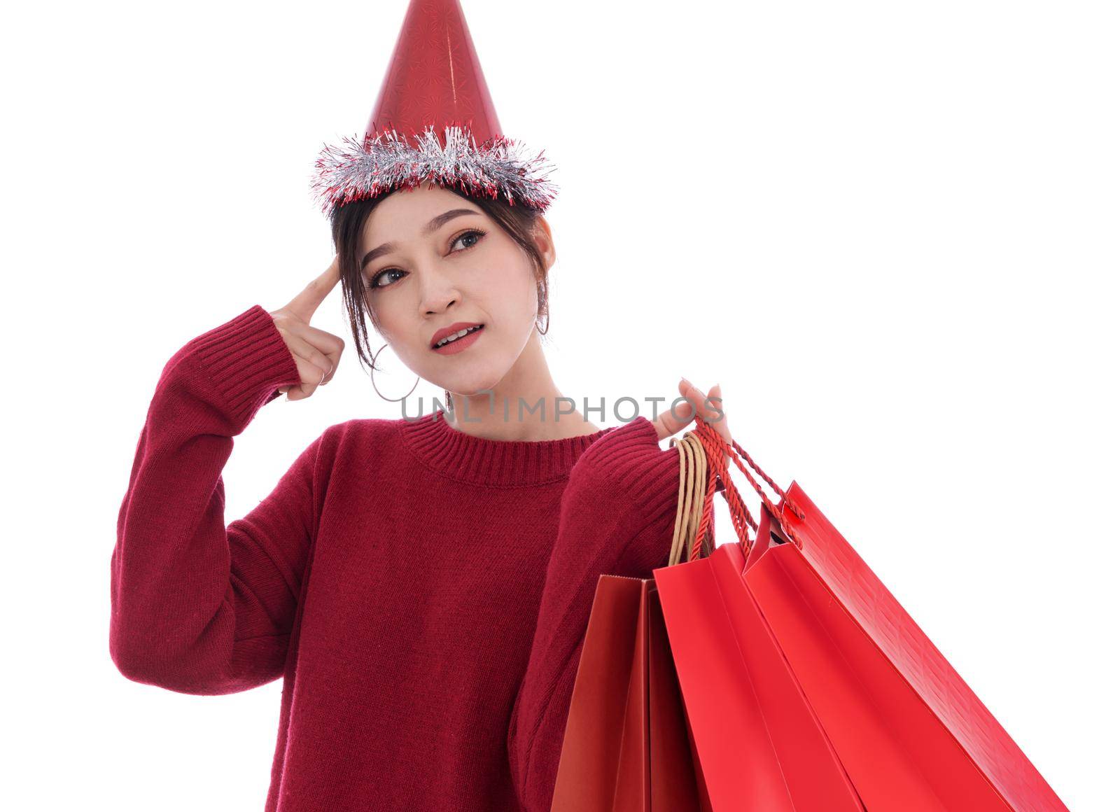 young woman thinking and holding shopping bag isolated on a white background (christmas concept)